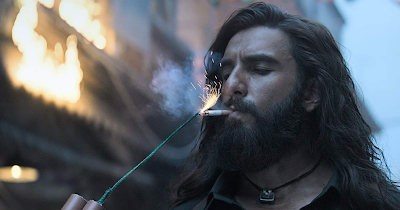 Ranveer Singh in a serious, action-ready pose from the movie Dhurandhar, looking intense and rugged.