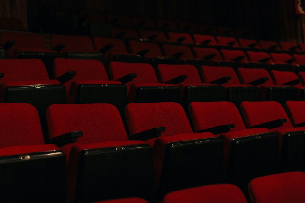 A large empty movie theater auditorium with red seats