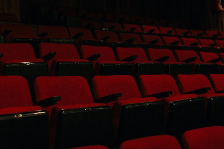 A large empty movie theater auditorium with red seats